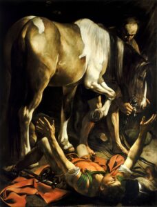 A painting by Caravaggio - 'Conversion on the Way to Damascus' . A horse stands over Saint Paul, himself having been knocked to the ground with hands extended in surprise as he looks upward