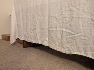 An image of the edge of the altar cloth at the rectory chapel of Queen of Angels parish, originally from Sacred Heart parish (Morton, WA). There is an embroidered text that reads 'In Remembrance Of Me'.