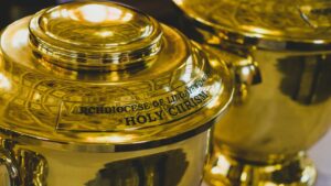 A photo of the brass vessel of the sacred chrism, with a metal engraving of "Archdiocese of Lingayen-Dagupan" and "Holy Chrism"